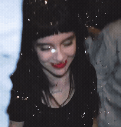 Mujer con confeti cayendo sobre su rostro GIF