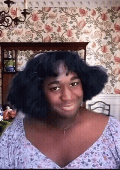 Woman With Cross Necklace And Floral Shirt GIF