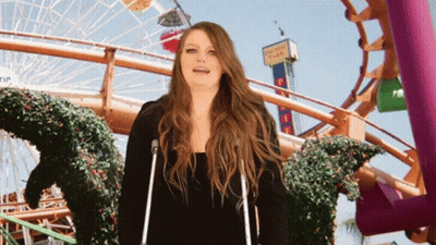 Woman With Crutches In Front Of Pacific Park Roller Coaster GIF