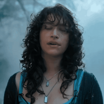 Woman With Curly Hair And Dog Tag Necklace GIF