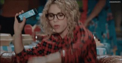 Woman With Curly Hair And Glasses Arms Up On Couch GIF