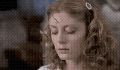Woman With Curly Hair And Hair Clip Looking Down GIF