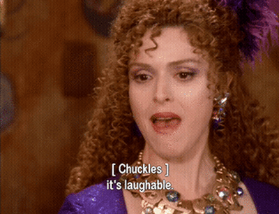 Woman With Curly Hair And Necklace Chuckles It's Laughable GIF