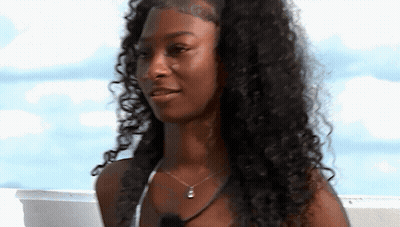 Woman With Curly Hair And Necklace Smiling GIF
