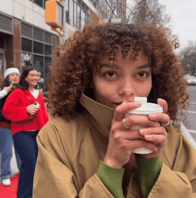 Woman With Curly Hair Holding Coffee GIF