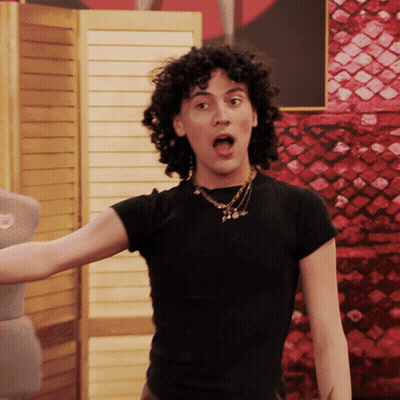 Woman With Curly Hair In Black Shirt And Necklace GIF