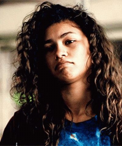 Woman With Curly Hair In Blue Shirt And Red Jacket GIF