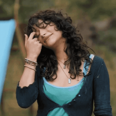Woman With Curly Hair In Blue Sweater And Tank Top GIF