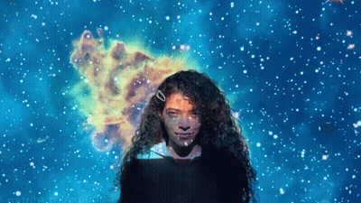 Woman With Curly Hair In Front Of Blue Starry Background GIF
