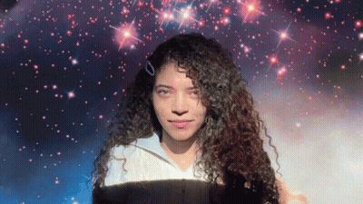 Woman With Curly Hair In Front Of Starry Background GIF
