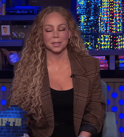 Woman With Curly Hair In Plaid Jacket And Black Top GIF