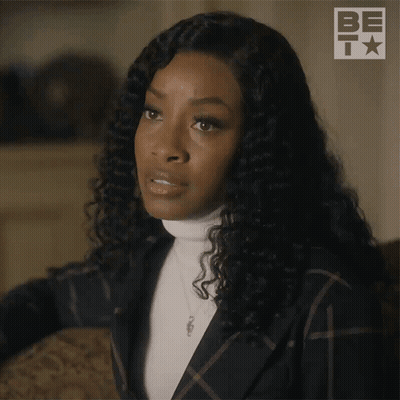 Woman With Curly Hair In Plaid Jacket And Turtleneck GIF