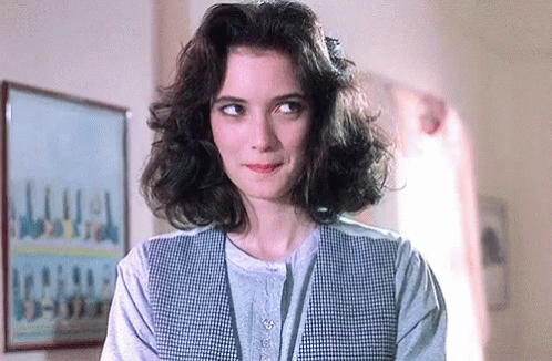 Woman With Curly Hair In Plaid Vest GIF