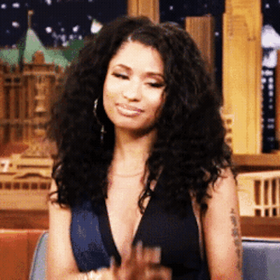 Woman With Curly Hair In Plunging Black Top GIF