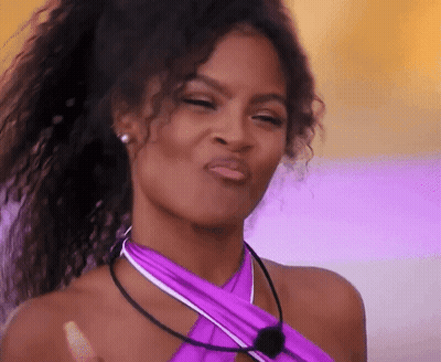 Woman With Curly Hair In Purple Top Making Face GIF