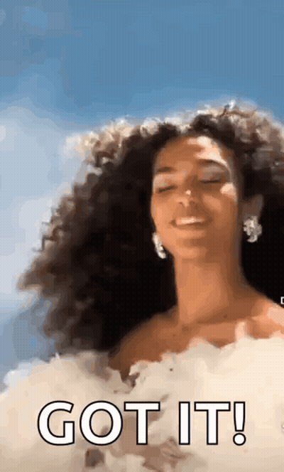 Woman With Curly Hair In White Dress Smiling GIF