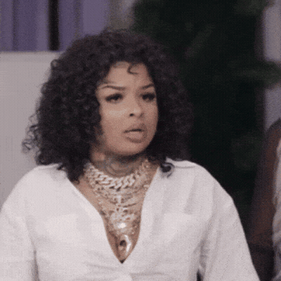 Woman With Curly Hair In White Shirt And Gold Necklace GIF