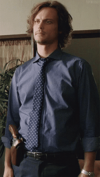 Woman With Curly Hair In Zebra Print Shirt On Couch GIF
