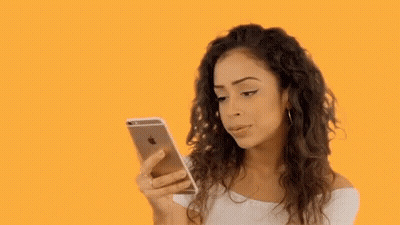 Woman With Curly Hair Looking At Cell Phone GIF