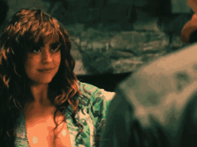Woman With Curly Hair Looking At Man In Green Shirt GIF