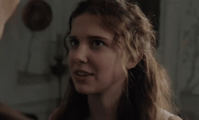 Woman With Curly Hair Looking At Man In Room GIF