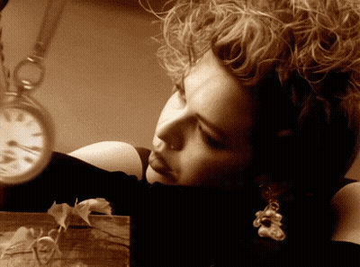 Woman With Curly Hair Looking At Pocket Watch GIF