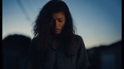 Woman With Curly Hair Looking Down GIF