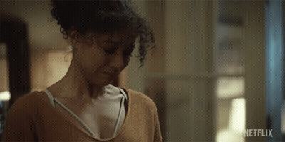 Woman With Curly Hair Looking Down Netflix Ad GIF