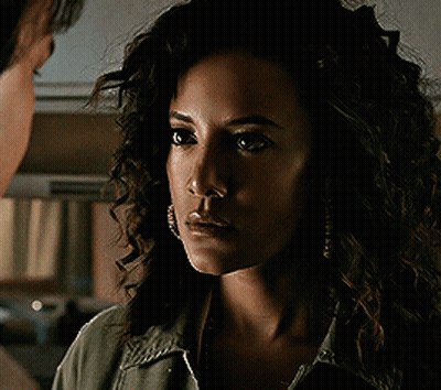 Woman With Curly Hair Looks At Man GIF