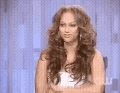 Woman With Curly Hair Making Funny Face In Chair GIF