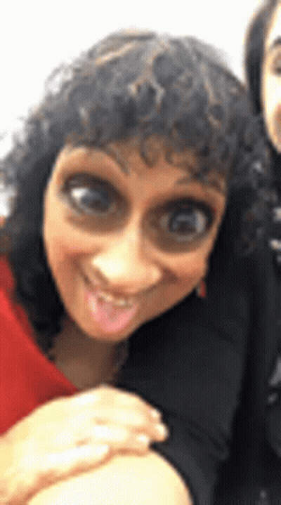 Woman With Curly Hair Making Funny Face Next To Another Woman GIF