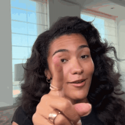 Woman With Curly Hair Pointing At Camera GIF