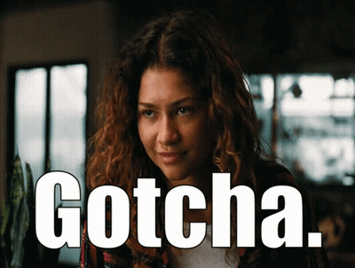 Woman With Curly Hair Saying Gotcha In Front Of Window GIF