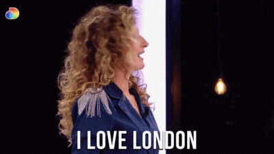 Woman With Curly Hair Says I Love London in Front of Light Bulb