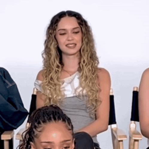Woman With Curly Hair Sitting In Director's Chair GIF