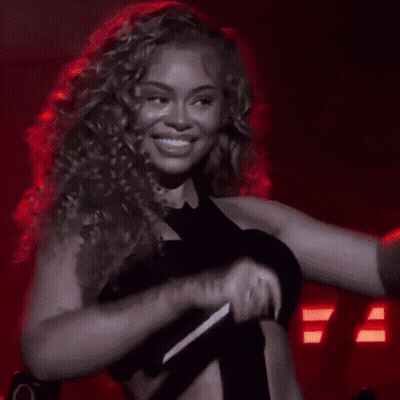 Woman With Curly Hair Smiling And Flexing GIF
