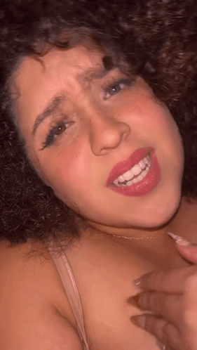 Woman With Curly Hair Smiling And Making Face GIF