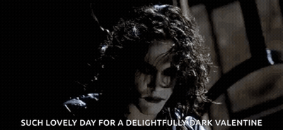Woman With Curly Hair Smiling In Dark Room GIF