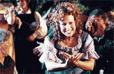 Woman With Curly Hair Smiling In Front Of Group GIF