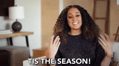 Woman With Curly Hair Smiling On Couch GIF