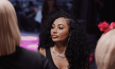 Woman With Curly Hair Wearing Zeus Necklace GIF