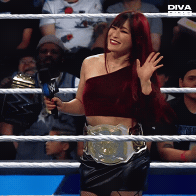 Woman With Diva Belt In Wrestling Ring Holding Microphone GIF
