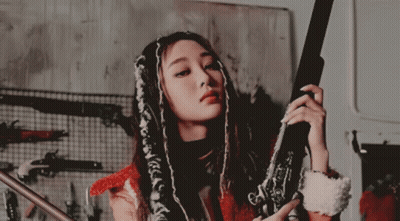 Woman With Dreadlocks Holding Gun GIF