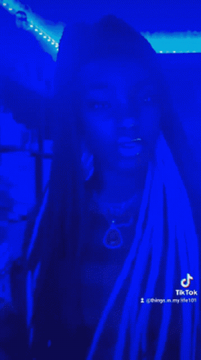 Woman With Dreadlocks In Dark Room With Blue Lights GIF