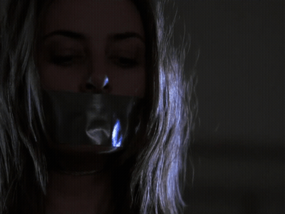 Woman With Duct Tape On Mouth Eyes Closed In Dark GIF