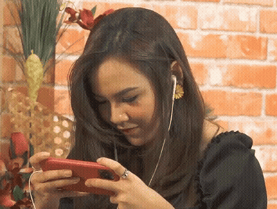 Woman With Ear Buds And Ring Looking At Phone GIF