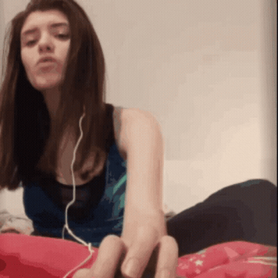 Woman With Earbuds Lying On Bed GIF