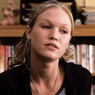 Woman With Earrings And Necklace Looking At Camera GIF