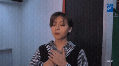 Woman With Eyes Closed In Plaid Shirt And Black Vest GIF