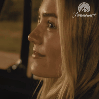 Woman With Eyes Closed Saying Show Me In Front Of Paramount Sign GIF